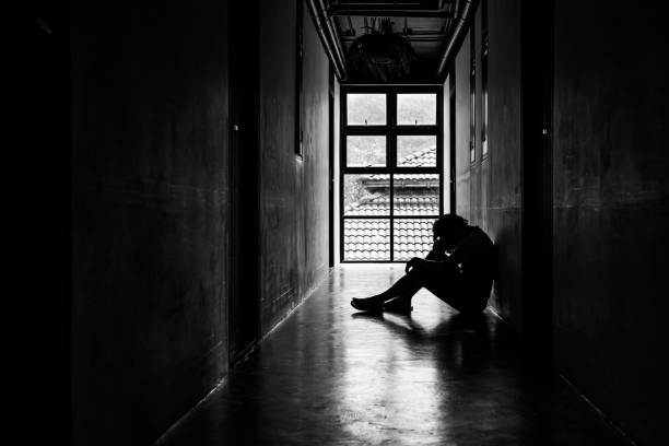 istock Lonely young man feeling depressed and stressed sitting in the dark walkway, Negative emotion and mental health concept 1297036387