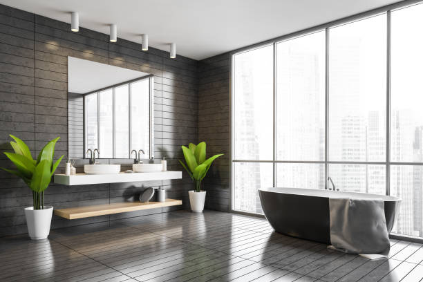 istock Panoramic gray tile bathroom corner with tub and sink 1297036488