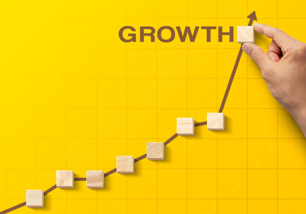 istock Wooden blocks arranged in an increasing graph with the word GROWTH on yellow background. Business growth, career growth or growth concept. 1297036653