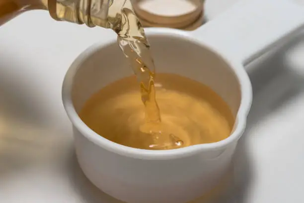 Pouring Apple Cider Vinegar in a Measuring Cup