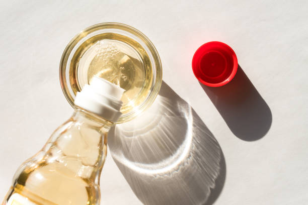 pouring rice wine vinegar in a bowl - vinagre fotografías e imágenes de stock