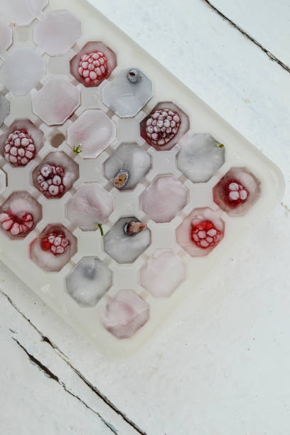 istock Ice cubes with berries. Ice tray with berries on white background. Top view 1297037916