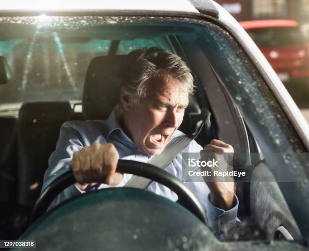 Man Shakes His Fist And Shouts In Road Rage As He Drives A Car Stock Photo - Download Image Now