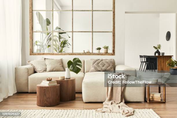 Modern Interior Of Open Space With Design Modular Sofa Furniture Wooden Coffee Tables Plaid Pillows Tropical Plants And Elegant Personal Accessories In Stylish Home Decor Neutral Living Room Stock Photo - Download Image Now