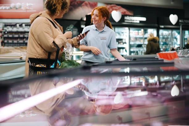 istock Customer asking supermarket employee for help finding a food item 1297039812