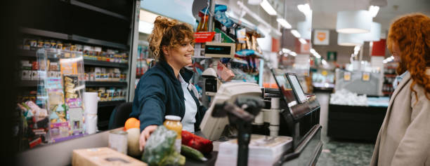 istock Cashier assisting customer at supermarket checkout 1297040571