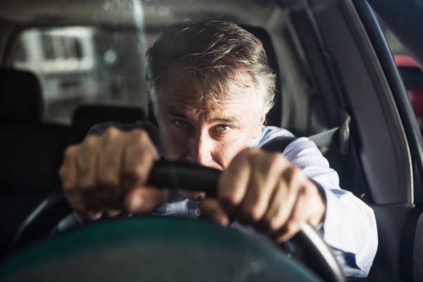 istock Man stares ahead in grim determination as he drives his car 1297040629