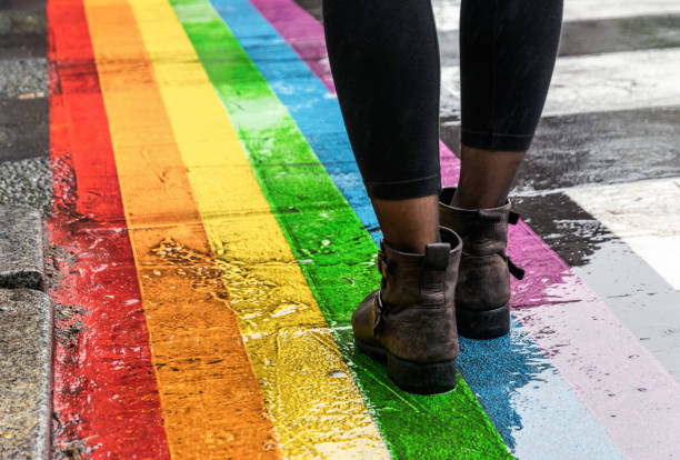 Legs walking on Gay rainbow crosswalk. Female legs walking on rainbow crosswalk on Gay pride. gay pride symbol stock pictures, royalty-free photos & images