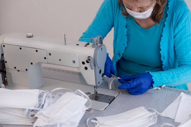 istock Cutting thread from the attached rubber band to the fabric. Face masks production. 1297042649