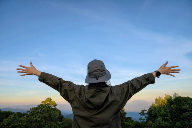 istock Rear freedom woman open arms at mountain peak 1297043634