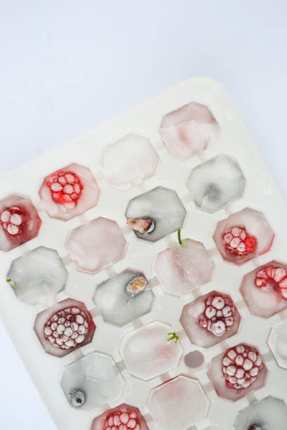 istock Ice cubes with berries. Ice tray with berries on white background. Top view 1297043931