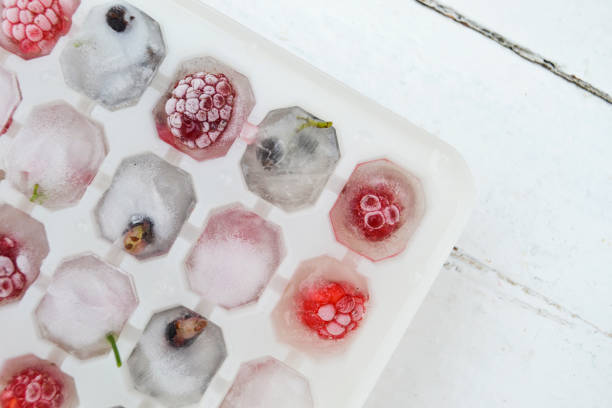 istock Ice cubes with berries. Ice tray with berries on white background. Top view 1297044744