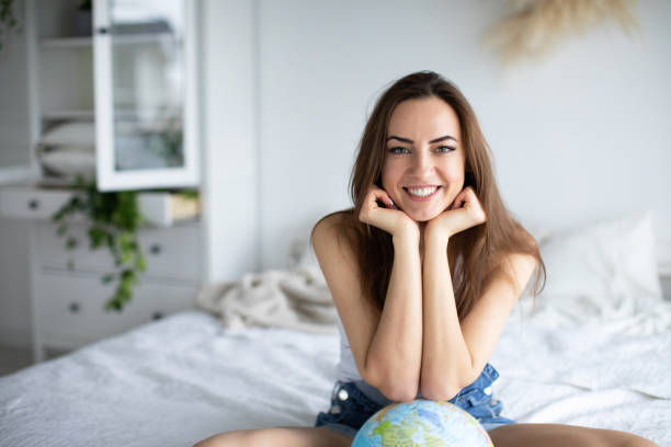 istock Young beautiful girl at home with a globe. 1297044787