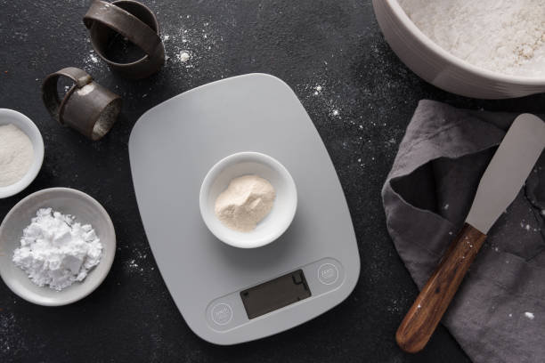 Weighing Xanthan Gum on a Digital Scale Weighing Xanthan Gum on a Digital Scale kitchen scale stock pictures, royalty-free photos & images