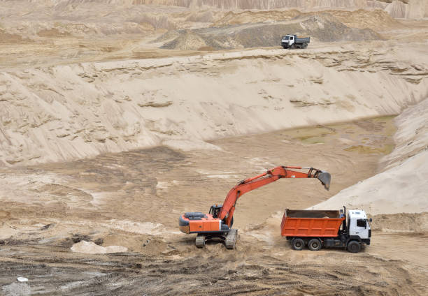 istock Excavator load the sand into dump truck in open-pit mining 1297048285