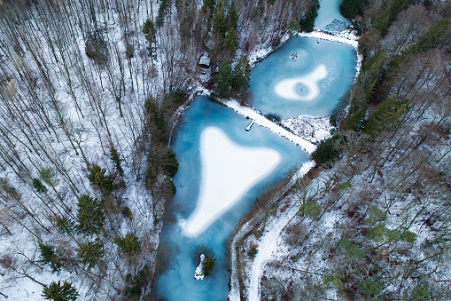 Frozen fishpond with a heart-shaped snow surface - aerial view