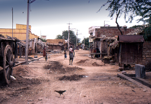 Small un-named settlement just outside the city of Bangalore India June 20 1988 dirt street with some residents in poor rural Indian village