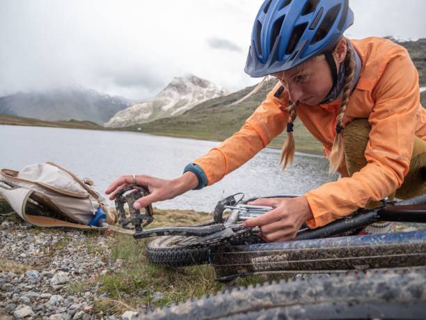 istock Woman fixing mountain bike on trail 1297052590