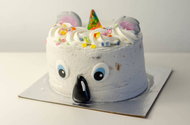 Madeira sponge layered with frosting and raspberry jam, covered in soft icing with edible decorations, koala bear-shaped cake,