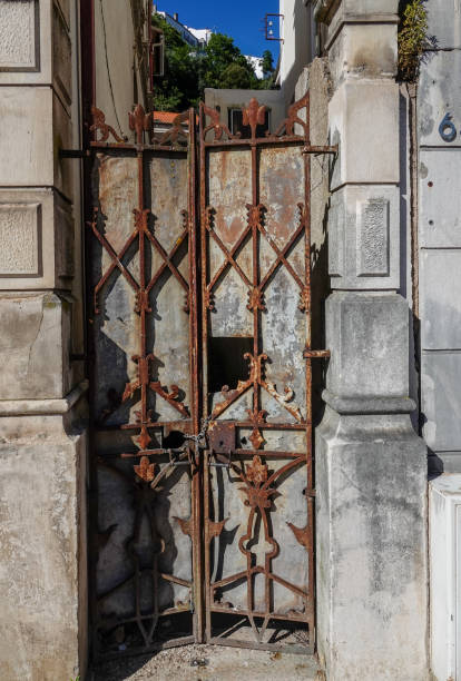 istock Rusty locked iron gate between stone walls. Coimbra, Portugal. 1297052951