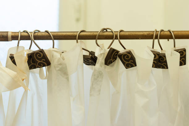 istock plastic Cream-colored shower curtain hanging on a string on metal hooks 1297055488