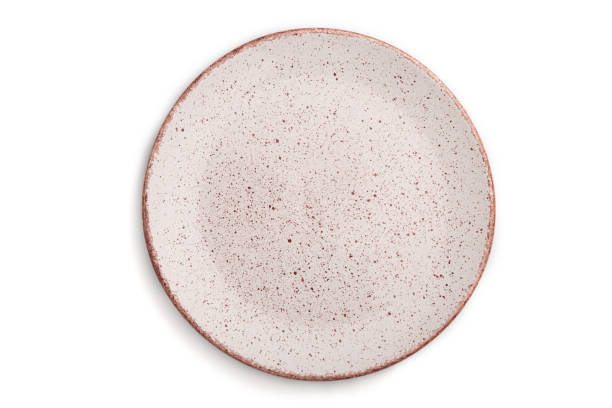 istock Empty pink dotted ceramic plate isolated on white background. Top view, close up. 1297056934