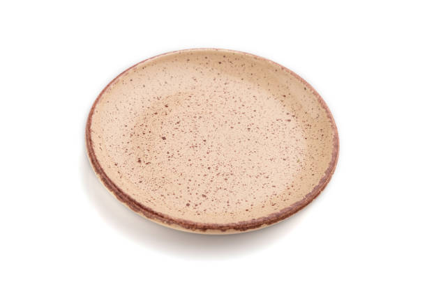 istock Empty beige dotted ceramic plate isolated on white background. Side view, close up. 1297057095