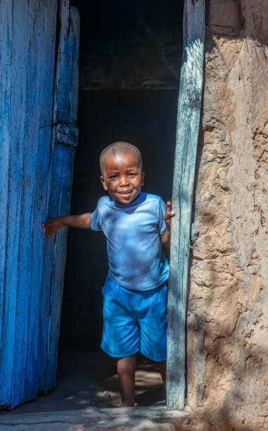 African child portrait in a village in the rural  Botswana standing in front of the house