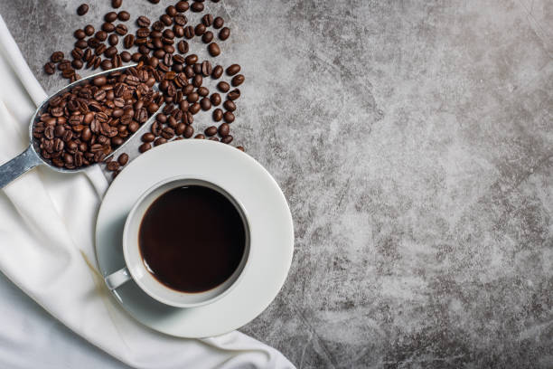 istock Background Coffee cup and beans on old kitchen table. Top view with copyspace for your text 1297060270
