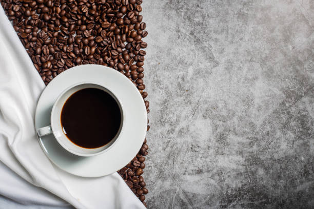 istock Background Coffee cup and beans on old kitchen table. Top view with copyspace for your text 1297060288