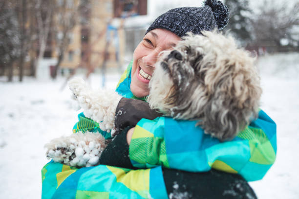 istock Senior woman playing with her dog outdoors on snow 1297060401