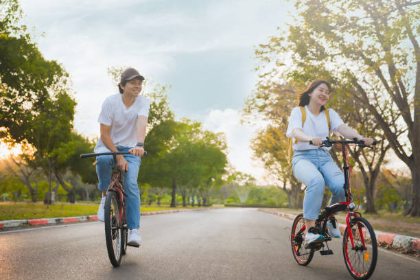 primavera viene concepto con la sensación feliz y alegre de pareja asiática montar en bicicleta juntos - comming fotografías e imágenes de stock