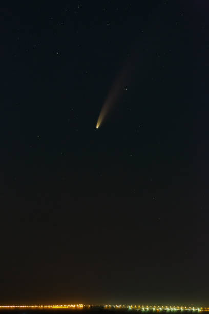 istock Bright comet C / 2020 F3 (NEOWISE) in the starry night sky. Deep space object above the horizon. 1297060420