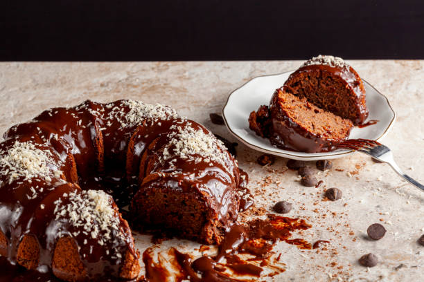 istock Angled side view of a gourmet round chocolate cake with coconut shreds on icing. 1297061204