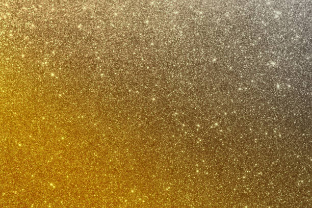 istock Glittering gold sequins with a gradient in silver textile background. Sequins on fabric in bright yellow and gray colors. 1297061577