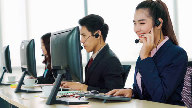 istock Business people wearing headset working in office 1297061821