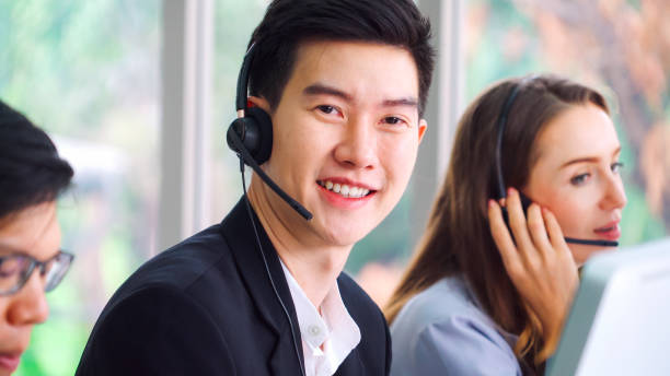 istock Business people wearing headset working in office 1297063885