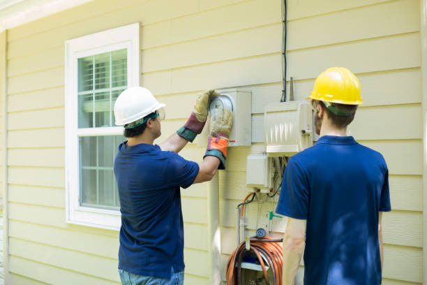 Electrical repair man working on outside meter of home. stock photo