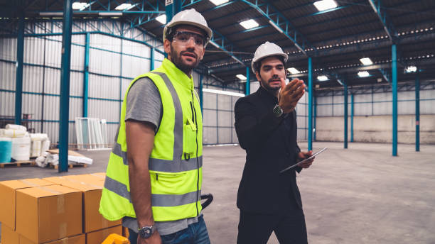 istock Factory workers deliver boxes package on a pushing trolley in the warehouse . 1297065284
