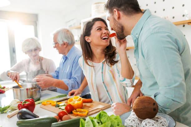 istock Two Generations of Couple tasting food having fun in kitchen 1297065588