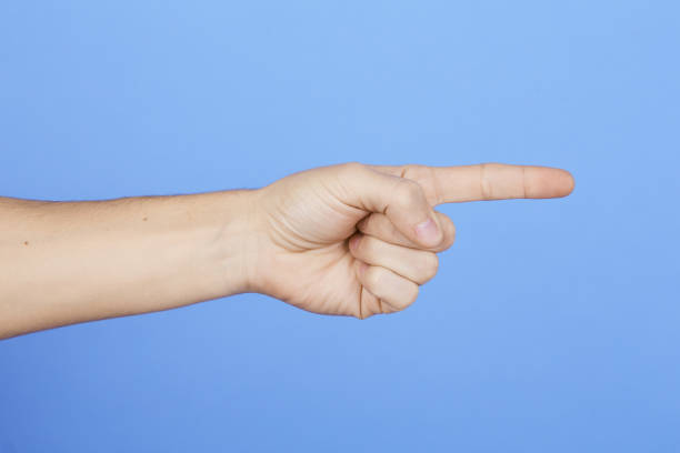 istock Caucasian man's hand pointing with index finger, isolated on blue background. 1297065779