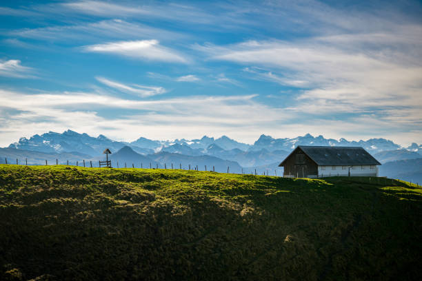 Small farm close to Chli Aubrig peak with beautiful views on majestic Alps Small farm close to Chli Aubrig peak with beautiful views on majestic Alps in background in Switzerland schwyz stock pictures, royalty-free photos & images