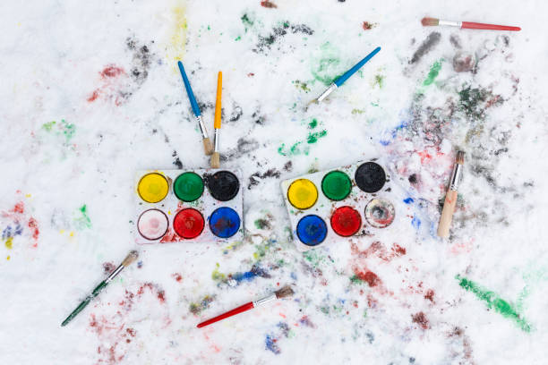 istock Watercolor painting boxes and brushes on the snow outdoors, winter activity 1297071861