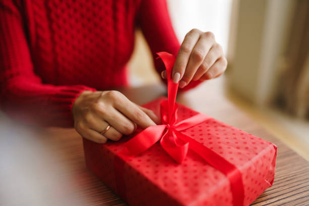 istock Beautiful smiling woman opens a present. Valentines day celebration concept. Relationship, surprise and love concept. 1297072445