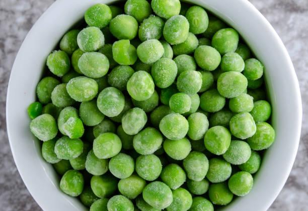 istock Frozen Green Peas in White Bowl 1297075218