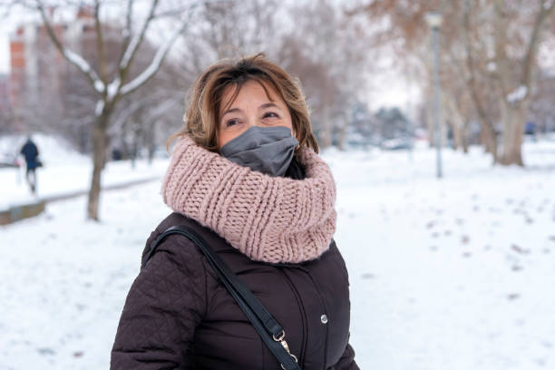 Senior woman walking on a winter day in the city  during COVID-19 pandemic.