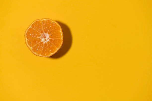 istock Half cut clementine tangerine isolated on orange color background. Copy space. 1297079247