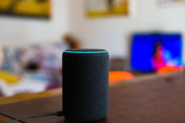 Amazon Alexa smart assistant device connected at home Amazon Alexa smart assistant device connected at home on table, defocused living room in background, no people virtual assistant stock pictures, royalty-free photos & images