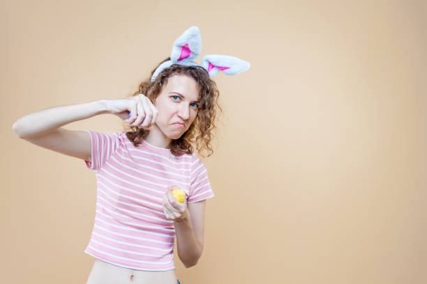 junge erwachsene frau auf isoliertem hintergrund - easter easter bunny fun humor stock-fotos und bilder