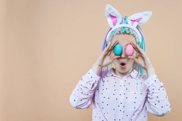 junge erwachsene frau auf isoliertem hintergrund - easter easter bunny fun humor stock-fotos und bilder